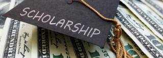 graduation cap on hundred dollar bills representing scholarships